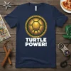 Navy blue t-shirt featuring a golden turtle shell graphic with the text "TURTLE POWER!" in bold white letters