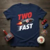Navy t-shirt with "TWO FAST" text and a rocket ship graphic, designed for a 2nd birthday