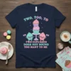 T-shirt design with text "TWO, TOO, TO TWO CUPCAKES DOES NOT SOUND TOO MANY TO ME" and cute smiling cupcakes