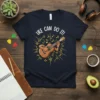 UKE CAN DO IT! text with a cartoon ukulele player graphic surrounded by musical notes on a navy t-shirt