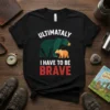 Black t-shirt with "ULTIMATALY I HAVE TO BE BRAVE" text and graphic of a large green bear and a small