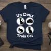 Un Deux Trois Cat T-Shirt featuring four black cat illustrations in circles and French text