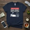 Navy t-shirt with white text "Unsolicited Advice Make Money While You Sleep" and graphic of person sleeping next to treasure