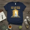 Navy t-shirt with yellow text "Until God Opens The Next Door Praise Him In The Hallway" and an illustration of