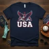 Navy blue t-shirt with "USA" text, a majestic eagle in flight, and mountain graphics, representing American pride