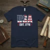 Navy blue t-shirt featuring "USA EST. 1776" design with American flag elements and red stars