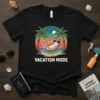 VACATION MODE text on a black t-shirt with a cartoon cat in a hammock on a beach, palm trees, and