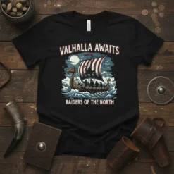 Black t-shirt with "Valhalla Awaits Raiders of the North" text and a Viking longship graphic sailing on waves under a