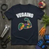 VEGAINS t-shirt featuring a flexing arm graphic made of colorful vegetables, with white text above