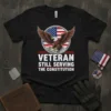 Veteran Still Serving The Constitution text with eagle and US flag design on a black t-shirt