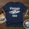 Vintage 1969 classic car design in white text and graphic on a navy blue t-shirt