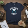 Volunteer Community Impact T-Shirt design featuring the word VOLUNTEER above a heart with gears and two figures, and COMMUNITY IMPACT