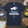 Navy t-shirt with white text "VOLUNTOLD" and a graphic of a megaphone over small people figures and a clipboard
