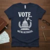 Navy blue t-shirt with white text "VOTE. WE'RE RUTHLESS." and graphic of US Capitol building with gavel and laurel wreath