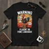 Warning Fluent in Fowl Language T-Shirt with a cartoon rooster wearing sunglasses and a leather jacket, speaking in speech bubbles