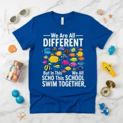 Blue t-shirt with text "We Are All DIFFERENT But In This SCHOOL SWIM TOGETHER," and colorful fish graphic