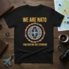 Black t-shirt with "WE ARE NATO TOGETHER WE ARE STRONGER" text and NATO emblem surrounded by flags and chains