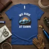 Blue t-shirt with "We Ride At Dawn" text and graphic of horses riding at sunrise over mountains