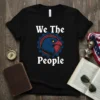 We The People text above and below an eagle graphic inside a gear, on a black t-shirt