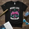 Weird Love Is True Love t-shirt with two pink and teal kissing fish, planets, and stars in a retro cosmic