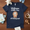 Navy t-shirt with "Welcome Little One #TitiSquad" text and graphic of hands holding a swaddled baby