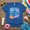 Welcome To The Pool Party text with inflatable rings, flamingo float, and beach ball on a blue t-shirt