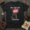 Black t-shirt with "Well, That's Not Bad A Good Sign" text and a cartoon cat holding a briefcase near a
