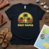 West Papua text with a retro sunset and palm trees graphic on a navy blue t-shirt
