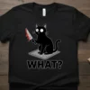 Black t-shirt design with the word "WHAT?" in bold white letters below a cartoon black cat holding a bloody knife