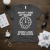 Dark grey t-shirt with white text: "WHAT I SEE AT WORK" above a melting clock face with letters F U