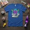 Blue t-shirt with "WHAT THE HELL?" text and a purple cartoon monster graphic with lightning bolts
