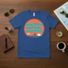 Blue t-shirt with "WHATEVER HAPPENS, HAPPENS," quote and a sailboat graphic, representing a calm mindset
