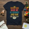 Navy t-shirt with bold, colorful text reading "WHEN GOD MADE ME HE GRINNED AND SAID 'This'll be fun'" and a