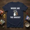 T-shirt with white text "WHERE ARE THE SNACKS?" above a cartoon raccoon holding a backpack with snacks