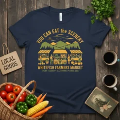 Navy blue t-shirt with "YOU CAN EAT the SCENERY WHITEFISH FARMERS MARKET" text and a graphic of a farmers market