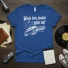 White text "Whole lotta shakin' goin on!" above a white outline of a vintage car on a blue t-shirt
