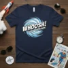 WHOOSH! SOUND BARRIER BREAKING comic style graphic on a navy t-shirt with swirling blue lines