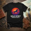Black t-shirt with "WILD SPIRIT FREEDOM AWAITS" text and a silhouette of a horse running against a vibrant sunset circle