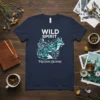 Navy t-shirt with "WILD SPIRIT FREEDOM BLOOMS" text and a stylized teal fox graphic surrounded by ornate swirls