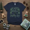 Winter ONEDerland Birthday Boy t-shirt with green text, pine trees, and a bear graphic