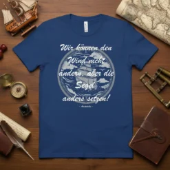T-shirt with white text "Wir können den Wind nicht ändern, aber die Segel anders setzen" and sailing ship graphic. Quote