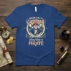 Work Like A Captain Play Like A Pirate quote on a blue t-shirt, featuring a pirate illustration with a ship's