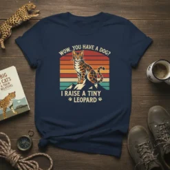 Bengal cat on mountain graphic with "Wow, You Have A Dog? I Raise A Tiny Leopard" quote, vintage sunset background