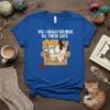 Yes, I Really Do Need All These Cats quote on a blue t-shirt, featuring multiple cartoon cats on a couch