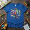 You Are Brave Unique Smart Enough Kind Loved Brilliant Neatful Strong tree design on a blue t-shirt with puzzle pieces