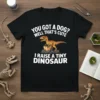 "You Got A Dog? Well That's Cute I Raise A Tiny Dinosaur" text with a graphic of a baby velociraptor