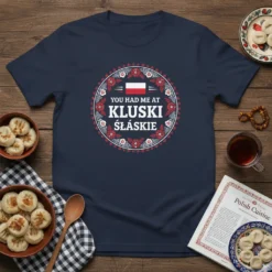 T-shirt design with "YOU HAD ME AT KLUSKI ŚLĄSKIE" text in a circular floral pattern with Polish flag accent