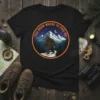 Bigfoot walking in snowy mountains with "You Know Where To Find Me" text on a black t-shirt design