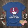 White goose wearing a pink scarf surrounded by red hearts, text reads "You Make My Heart Go Honk" on a