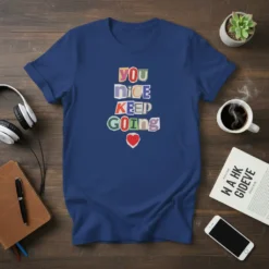 YOU NICE KEEP GOING text design with colorful cut-out letters and a red heart graphic on a navy blue t-shirt